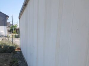 甲斐市K様邸 倉庫の施工前側面全体。全体的に色あせと劣化が進行している状態。